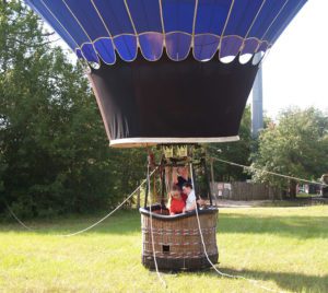 Three people in hot air balloon waiting to be released into the air